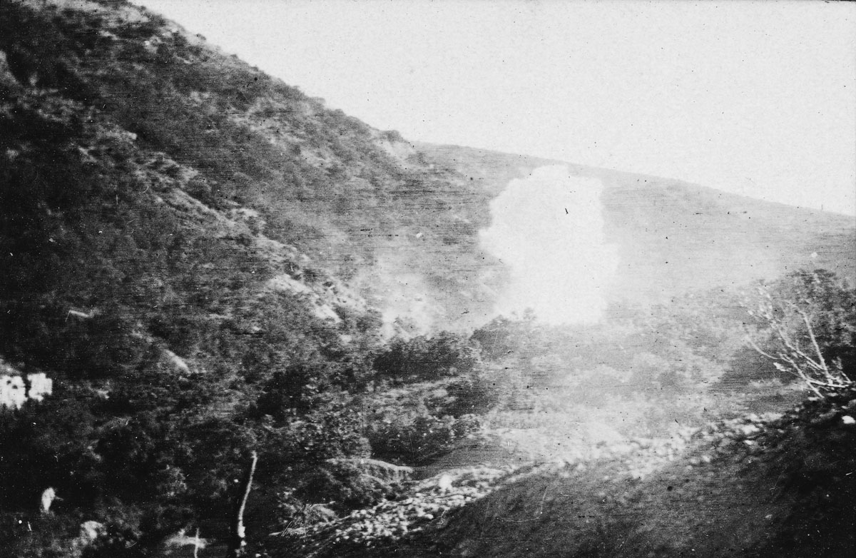 A shell bursting over a valley.